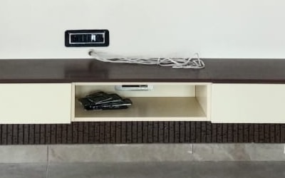 Close-up of the console: espresso top, cream drawer fronts, an open niche, and the fluted band below.